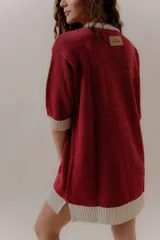 Vestido corto tejido en punto color negro con cuello, puños y ruedo en blanco.