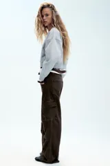 Pantalón cargo de tiro medio confeccionado en denim negro con efecto lavado. Presenta bolsillos laterales con solapa, bolsillos delanteros y traseros, corte recto y cinturón del mismo tejido incluido con hebilla metálica.