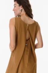 Mono largo color beige, de corte amplio y sin mangas, con escote en V.