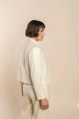 Chaqueta de sastrería color crema, entallada y con cuello erguido. Prenda forrada de lana fina sin teñir.