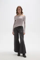 Sweater de punto acanalado color gris claro, con diseño de hombros descubiertos y cuello asimétrico drapeado. Presenta mangas largas y un corte ajustado al cuerpo.