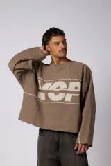 Buzo oversize de corte boxy, confeccionado en algodón rústico de alto gramaje en color beige. Presenta cuello redondo con borde crudo, mangas largas y una estampa frontal con el texto VCP delimitado por líneas horizontales blancas.