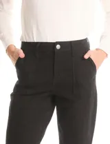 Pantalón de corte crop, color gris, con diseño de cinco bolsillos, cierre frontal con botón y ruedo irregular con terminación desflecada.
