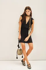 Vestido corto negro con escote profundo en V, mangas cortas con volados, cintura elastizada y detalle de volado en la cintura.