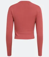 Blusa corta de tejido de punto color salmón, con cuello redondo, mangas largas, recortes frontales y detalle retorcido.