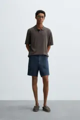 Polo de punto de corte regular fit, confeccionado en una mezcla de algodón y lyocell. Presenta cuello de solapa con cierre frontal de botones, manga corta y acabados en rib en puños y bajo.