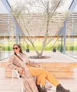 Tapado largo de paño liviano con diseño de cuadros en tonos marrones. Presenta solapas clásicas, bolsillos laterales con detalles en cuero y tajos profundos en los costados.