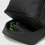 Mochila deportiva negra de diseño minimalista, con múltiples compartimentos, incluyendo espacio térmico para raquetas, bolsillo inferior ventilado para calzado y compartimento interno para laptop.