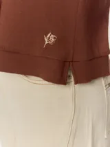 Remera negra de punto fino, con mangas cortas, cuello redondo y corte relajado. Cuenta con costuras verticales decorativas en el frente.