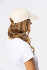 Gorro con visera de lona rosado con bordado frontal en tonos verde y violeta.