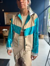 Camisa color beige con detalles en azul metalizado en mangas y pecho, y plateado en cuello y puños.