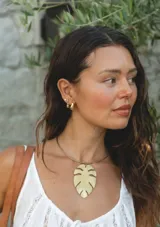 Gargantilla de bronce con dije grande en forma de hoja de monstera.