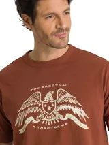 Remera Caterpillar de manga corta y cuello redondo, color marrón terracota, con gráfico estampado en el pecho inspirado en el legado de la marca.