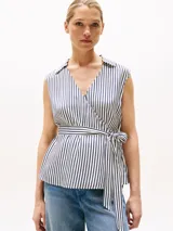 Blusa sin mangas con cuello camisero y diseño cruzado a rayas verticales blancas y azules.
