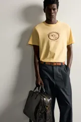 Camiseta regular fit de color amarillo, de cuello redondo y manga corta, con estampa frontal en contraste de un rancho y la inscripción "Rancho Lane Worn Heritage".