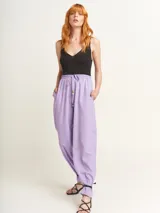 Pantalón de lino color lila, tiro alto, corte palazzo con elástico en la pretina, bolsillos laterales y dobladillo invisible.