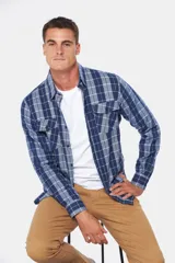 Camisa de franela a cuadros azul y blanco, de manga larga, con dos bolsillos frontales con solapa abotonada.