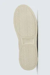 Zapatillas marrones de estilo retro con cordones, capellada de cuero y suela de goma color crema.