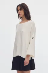 Sweater de punto color rojo, con cuello bote, mangas largas evasé y diseño amplio.