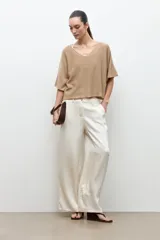 Sweater oversized de tejido liviano, color tostado, con escote en V y mangas cortas holgadas.
