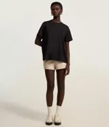 Remera de corte boxy con cuello redondo y mangas cortas. Confeccionada en algodón, presenta un diseño minimalista sin estampas con sisa caída.