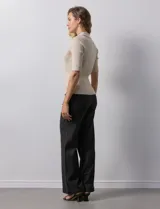 Buzo azul de tejido acanalado, con cuello solapa y escote en V en tejido calado.