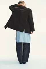 Blazer oversize de corte recto con estampado de raya diplomática. Presenta cuello con solapa, cierre frontal cruzado con botones, hombros caídos y bolsillos delanteros con vivo.