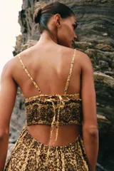 Vestido midi de broderie en tonos mostaza y marrón, con escote en V, tirantes finos ajustables, abertura cut-out en la cintura y espalda con nido de abeja elástico.