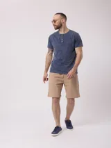 Remera azul con cuello redondo y tapeta con botones. Tiene un acabado desgastado.