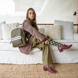 Mochila mediana color rosa, de nylon con detalles en símil cuero en el bolsillo frontal. Tiene asa de mano y correas regulables.