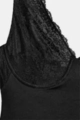 Body negro con aros, escote en pico y detalles de encaje a tono en las copas y en el borde de las piernas. Cuenta con tirantes anchos y cierre inferior con botones a presión.