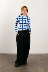 Polera de cuello alto azul con estampado de lunares blancos, mangas largas y corte ajustado.