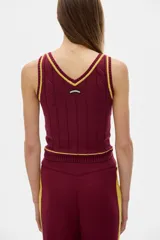 Musculosa tejida color borgoña con cuello en V y ribete amarillo.