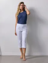 Pantalón capri blanco de gabardina elastizada. Pretina ancha elastizada, delantera con bolsillos simulados y trasera con bolsillos aplicados.
