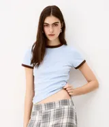 Blusa tipo baby tee celeste de algodón, con mangas cortas y cuello redondo ribeteados en marrón oscuro.