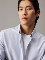 Camisa celeste de corte regular, con cuello abotonado y mangas largas.