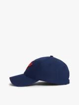 Gorra de béisbol azul marino con diseño de seis paneles y visera curva. Cuenta con bordado en color rojo en la parte frontal con las iniciales TH en fuente script y la firma de la marca en el lateral.