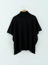 Poncho de tejido de punto color marrón chocolate, con cuello alto tipo polera y mangas cortas amplias. Presenta un diseño holgado con terminaciones acanaladas en el ruedo.