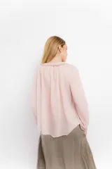 Blusa celeste de algodón con escote en V con lazos y mangas largas abullonadas con puños elásticos.