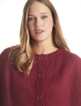 Capa de punto color bordó con diseño envolvente de doble capa superpuesta. Presenta cuello a la base, cierre frontal con botones y mangas estilo japonés con terminaciones acanaladas.
