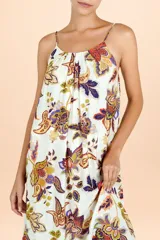Vestido largo con tirantes finos, escote redondo y falda amplia con volado en el ruedo. Presenta un estampado botánico tipo paisley en tonos cálidos sobre fondo claro.