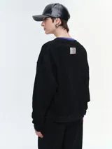 Buzo de cuello redondo y manga larga, con diseño oversize y corte relajado. Presenta puños y ruedo acanalados, confeccionado en tejido de textura suave.