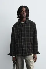 Sobrecamisa de corte relajado confeccionada en tejido de algodón, con diseño a cuadros, cuello solapa, cierre frontal de botones y bolsillo en el pecho.