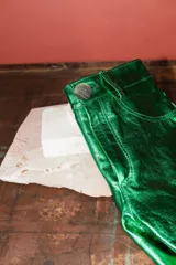 Shorts de cuero de tiro medio y corte recto, con acabado metalizado en color turquesa, bolsillos funcionales y cierre frontal con botón.