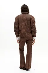 Pantalón de cuero de oveja color marrón, de corte recto con tajos en el ruedo. Presenta tiro medio con elástico interno y forro con stretch.