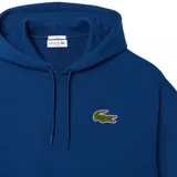 Buzo canguro verde con capucha y cordones ajustables, bolsillo tipo canguro y logo de Lacoste bordado en el pecho.