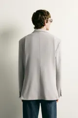 Blazer regular fit azul marino confeccionado en tejido con elasticidad, con cuello de solapas de muesca, cierre frontal con botones y bolsillos con solapa en la cadera.