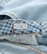 Pantalón de jean azul claro, modelo wide leg, con bolsillos cargo laterales y cintura ajustable.