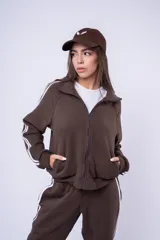 Campera tipo bomber color negro con cuello alto y cierre frontal. Presenta dos líneas blancas paralelas a lo largo de las mangas y puños elásticos acanalados.