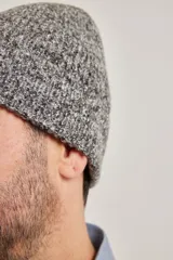 Gorro tipo fishman de tejido de punto melange, color gris jaspeado con detalles en azul.